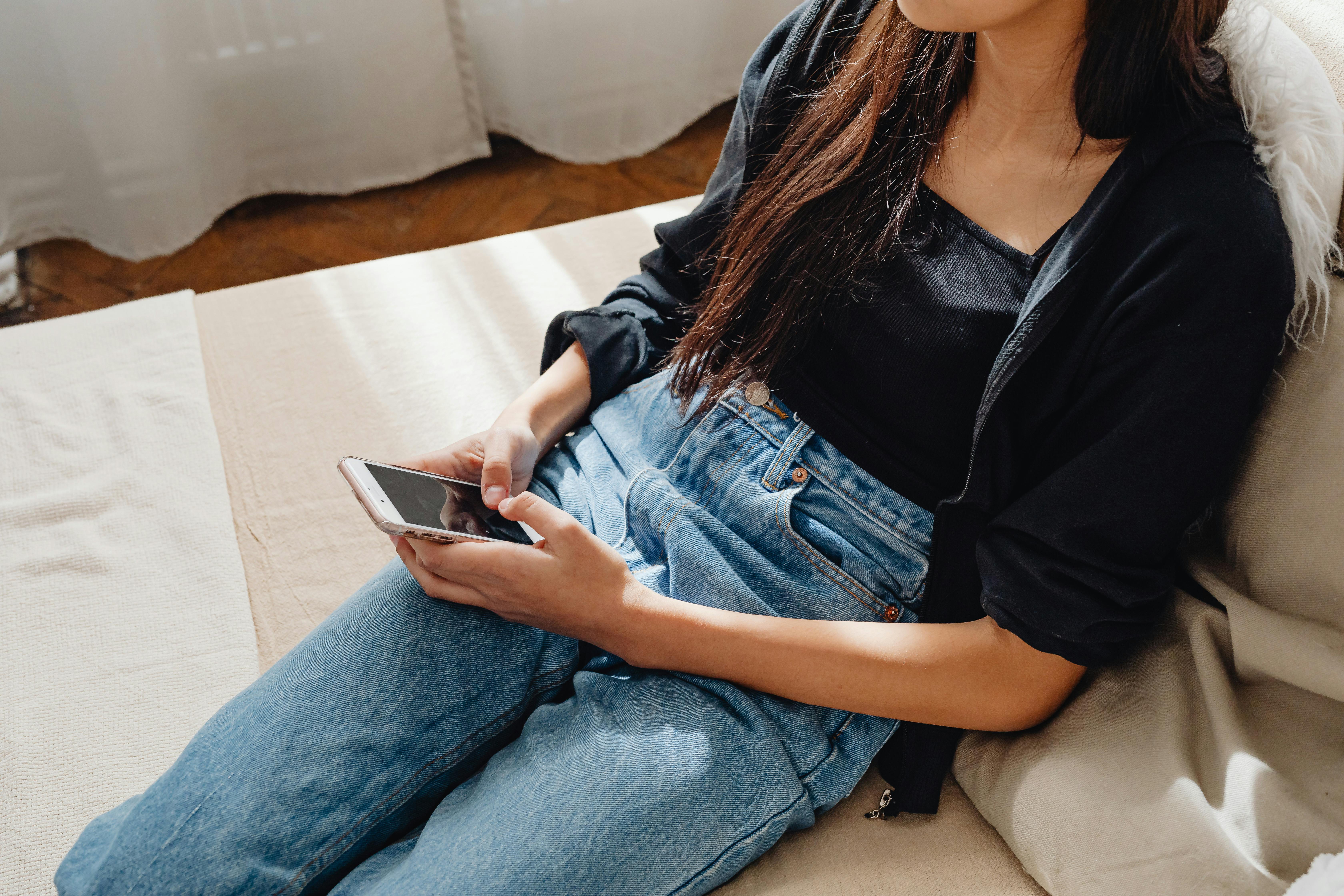ソファでスマホを操作している女性